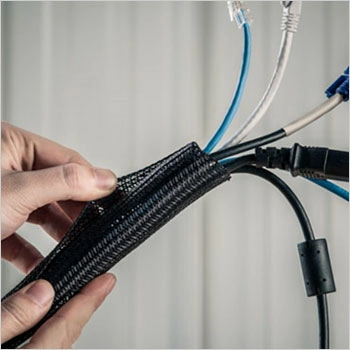 Hands pulling apart Techflex expandable sleeving to show how cables fit inside